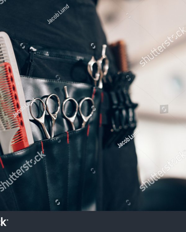stock-photo-closeup-of-scissors-and-combs-in-a-salon-holster-pouch-hairdressing-tools-inside-a-hairdresser-684511561